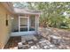 View of the backyard featuring a screened lanai, stone walkway, and mature trees at 618 Meadow Park Dr, Minneola, FL 34715