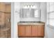 Bathroom featuring double sinks, a tiled shower, and granite vanity at 618 Meadow Park Dr, Minneola, FL 34715