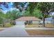 Charming single-story home features a well-maintained lawn, mature trees, and attached two-car garage at 618 Meadow Park Dr, Minneola, FL 34715