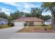 Charming single-story home with a well-manicured lawn, mature trees, and a two car garage at 618 Meadow Park Dr, Minneola, FL 34715