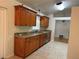 Traditional kitchen featuring wood cabinets, granite countertops, stainless steel appliances, and tile flooring at 618 Meadow Park Dr, Minneola, FL 34715