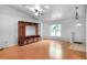 Spacious living room featuring hardwood floors, a large window, and an entertainment center at 618 Meadow Park Dr, Minneola, FL 34715