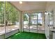 Enclosed patio featuring screened windows, artificial turf, and views of the landscaped backyard at 618 Meadow Park Dr, Minneola, FL 34715