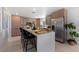 Modern kitchen with stainless steel appliances, quartz countertops, and stylish island seating for dining at 6340 Chorus Dr, Mascotte, FL 34753