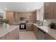 Well-lit kitchen featuring wood cabinets, stainless steel appliances, and marble countertops at 6340 Chorus Dr, Mascotte, FL 34753
