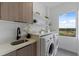 Well-equipped laundry room with modern appliances, custom cabinetry, and ample counter space, designed for convenience at 6340 Chorus Dr, Mascotte, FL 34753