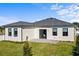 Home backyard featuring a well-maintained lawn and a covered patio at 6427 Chorus Dr, Mascotte, FL 34753