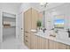 Bathroom featuring double sinks, wood cabinets, and a walk-in closet at 6427 Chorus Dr, Mascotte, FL 34753