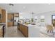 Modern kitchen with stainless steel appliances, island with seating, and open to living and dining areas at 6427 Chorus Dr, Mascotte, FL 34753