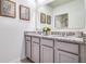 Bathroom featuring double sink vanity with granite countertop, gray cabinets, and decorative artwork at 7054 Painted Bunting Way, St Cloud, FL 34773