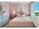 Elegant bedroom with a canopy bed, pink accents, and decorative butterfly accents at 7054 Painted Bunting Way, St Cloud, FL 34773
