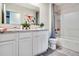 Well lit bathroom featuring a tub/shower combo and a double sink vanity with granite countertops at 7059 Painted Bunting Way, St Cloud, FL 34773