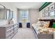 Bright bedroom featuring an oversized dresser and a window with neighborhood views at 7059 Painted Bunting Way, St Cloud, FL 34773