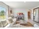 Comfortable living room featuring a sofa, television, decorative mirror, an area rug, and access to the adjacent room at 7059 Painted Bunting Way, St Cloud, FL 34773