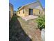 A full shot of the backyard with a small patio and a walkway along the home at 7228 Spring Villas Cir, Orlando, FL 32819