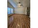 Comfortable bedroom featuring hardwood floors and natural light from a large window at 7228 Spring Villas Cir, Orlando, FL 32819