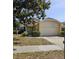 Well-maintained single-Gathering home featuring a two-car garage, manicured lawn, and inviting entrance at 7228 Spring Villas Cir, Orlando, FL 32819