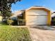 Quaint single-Gathering home featuring a spacious garage, complemented by lush greenery and mature trees at 7228 Spring Villas Cir, Orlando, FL 32819