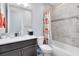 Tiled bathroom featuring a shower and tub combination, stylish shower curtain and dark vanity at 7873 Dausset St, Orlando, FL 32827