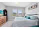 Bedroom with two large windows, TV, dresser and black iron bed frame with blue and teal bedding at 7873 Dausset St, Orlando, FL 32827