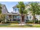 Charming two-story home boasts a welcoming front porch, solar panels, manicured landscaping, and classic architectural details at 7873 Dausset St, Orlando, FL 32827