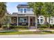 Charming two-story home boasts a welcoming front porch, solar panels, manicured landscaping, and classic architectural details at 7873 Dausset St, Orlando, FL 32827