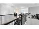 Bright loft area with stairway, neutral walls, and black metal railings overlooks a quiet space at 7873 Dausset St, Orlando, FL 32827