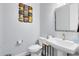 Stylish powder room with pedestal sink, modern faucet, and decorative wall art at 7873 Dausset St, Orlando, FL 32827