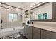 Updated bathroom features a shower over tub, modern vanity, decorative mirror, and wood floating shelves at 100 Kennison Dr, Orlando, FL 32801