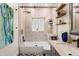 Updated bathroom features a shower over tub, modern vanity, decorative mirror, and wood floating shelves at 100 Kennison Dr, Orlando, FL 32801