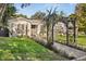 Charming home featuring a well-manicured front yard, a decorative pergola, and beautiful landscaping at 100 Kennison Dr, Orlando, FL 32801