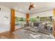 Bright living room features an accent fan, hardwood floors, natural light, and view to backyard landscaping at 100 Kennison Dr, Orlando, FL 32801