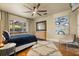 Cozy main bedroom boasts a ceiling fan, wood floors, and a large window with backyard views at 100 Kennison Dr, Orlando, FL 32801