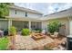 Landscaped backyard features a stone patio with a fire pit and outdoor seating area at 101 W Oakland Ave, Oakland, FL 34760
