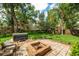 A spacious backyard featuring a patio, a fire pit, and lush green grass at 101 W Oakland Ave, Oakland, FL 34760
