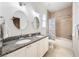 Bathroom with double sinks, granite countertops, and a shower-tub combination at 101 W Oakland Ave, Oakland, FL 34760
