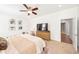 Bright bedroom featuring a ceiling fan, a dresser, and multiple art pieces on the wall at 101 W Oakland Ave, Oakland, FL 34760