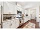 Updated kitchen showcasing stainless steel appliances, white cabinetry and stone countertops at 101 W Oakland Ave, Oakland, FL 34760