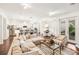 Bright, open living room featuring a sectional sofa, a cozy chair, and an adjacent dining area and kitchen at 101 W Oakland Ave, Oakland, FL 34760