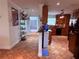 Hallway connecting to the kitchen with tile flooring, kitchen with wooden cabinets, and display cabinet at 10125 Matchlock Dr, Orlando, FL 32821