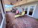 Covered patio with brick flooring, stylish lounge chairs, ceiling fan, and ample space for outdoor seating at 10125 Matchlock Dr, Orlando, FL 32821