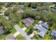 Expansive aerial view showcases a well-maintained home, lush landscaping, and screened-in pool in a serene, tree-lined neighborhood at 1024 Destin Dr, Lake Wales, FL 33898