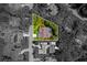 Highlighted aerial view focuses on a property with a screened-in pool, manicured lawn, and a backdrop of mature trees at 1024 Destin Dr, Lake Wales, FL 33898