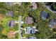 Bird's-eye view featuring a house with screened-in pool, nestled among lush trees and well-manicured lawns in a quiet neighborhood at 1024 Destin Dr, Lake Wales, FL 33898