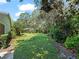 Large, well-maintained backyard with lush green grass and mature trees offers plenty of space at 1024 Destin Dr, Lake Wales, FL 33898
