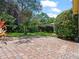 Spacious brick patio surrounded by lush, mature landscaping creates a private outdoor oasis at 1024 Destin Dr, Lake Wales, FL 33898