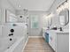 Bright bathroom featuring a soaking tub, walk-in shower, dual vanities and modern fixtures at 1024 Destin Dr, Lake Wales, FL 33898