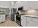 Modern kitchen showcasing stainless steel appliances, white cabinetry, and beautiful backsplash at 1024 Destin Dr, Lake Wales, FL 33898