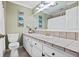 Well-lit bathroom features a large mirror, tiled counter, and white cabinets at 103 Greenleaf Ln, Altamonte Springs, FL 32714