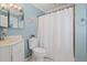 Bathroom with blue walls featuring a sink, toilet, and shower with curtain at 103 Greenleaf Ln, Altamonte Springs, FL 32714